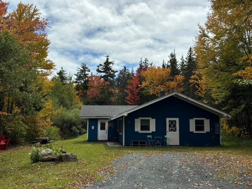 Ahmeek's blue façade in autumn, with bistro seating by the front door